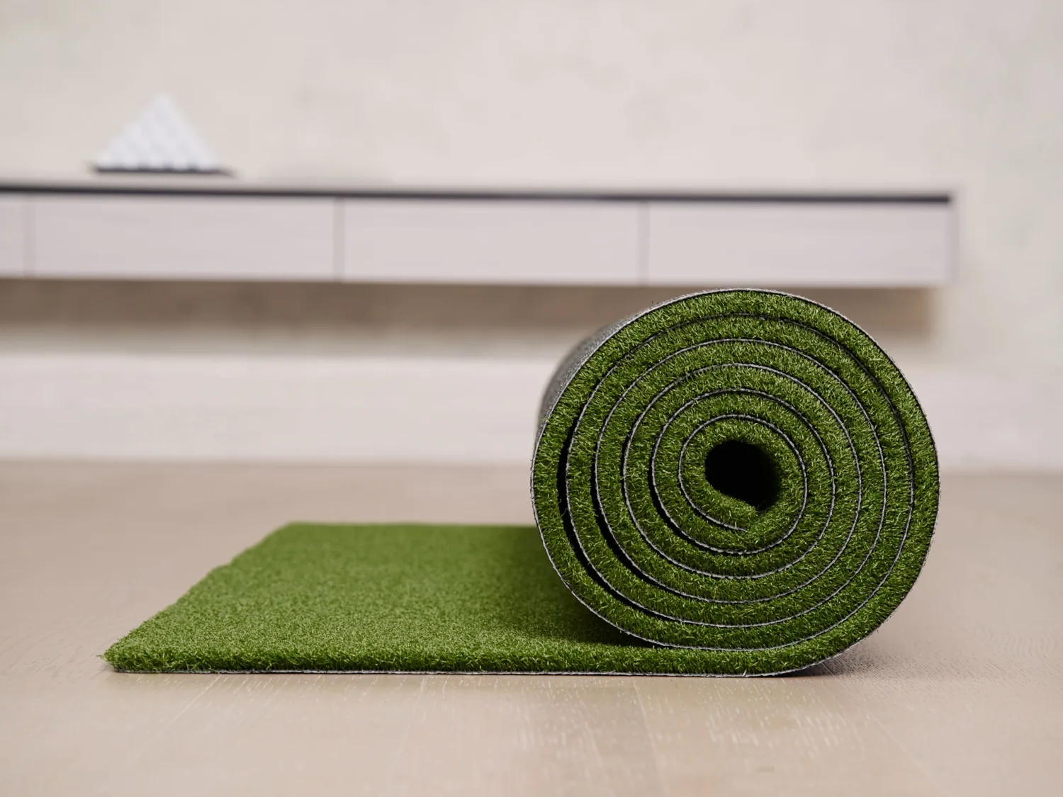Roll of artificial grass showing turf fibers and backing